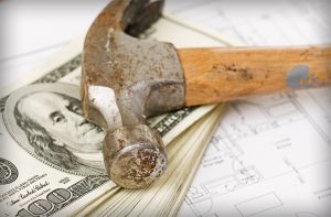 Hammer on top of a 100 dollar bill